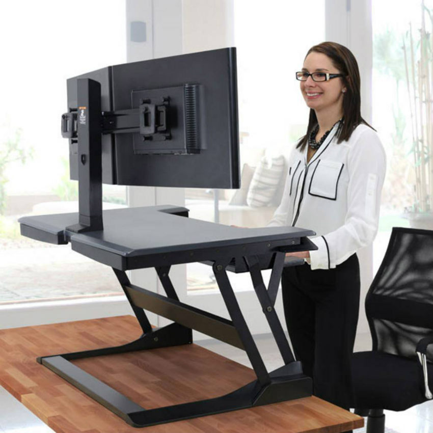 Happy women using Ergotron in office while working