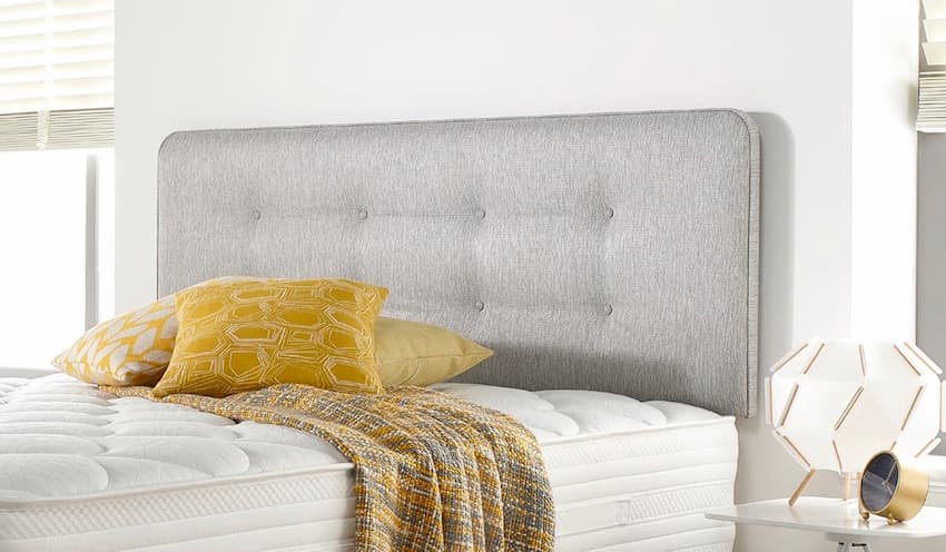 grey headboard for bedroom with white bedding and side table with a lamp