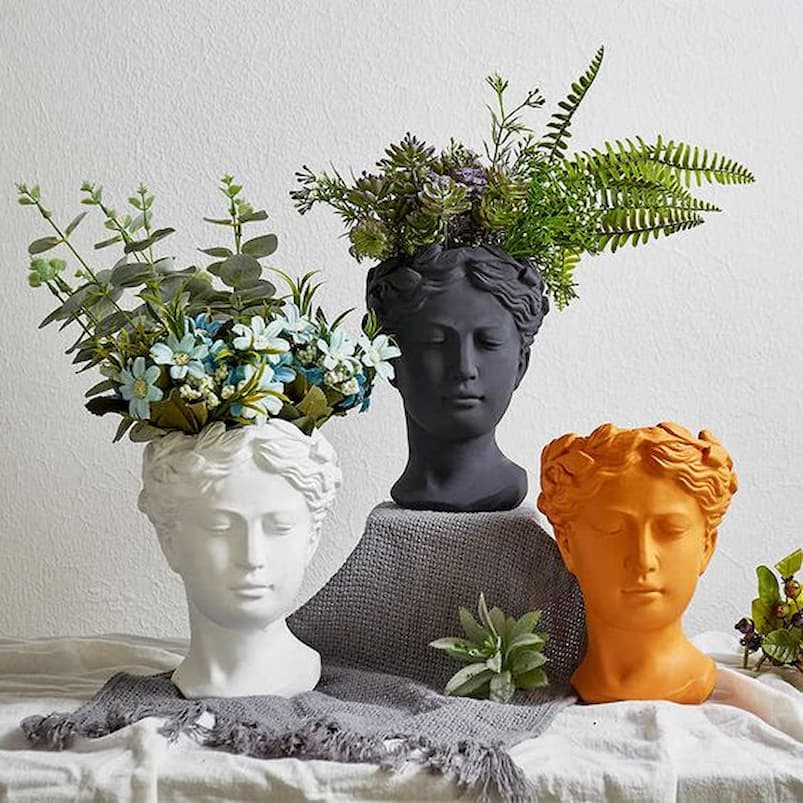 head sculpture with flowers growing inside