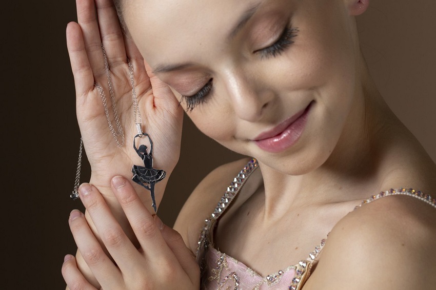 Woman holding ballerina necklace