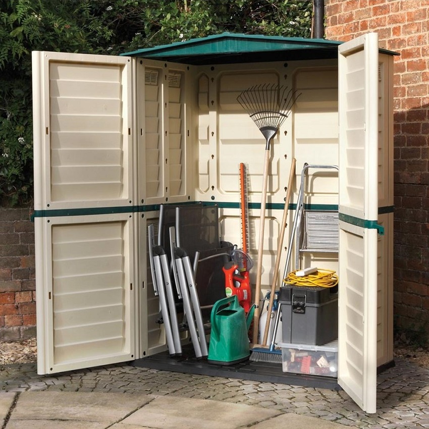 opened metal garden shed with garden tools inside 