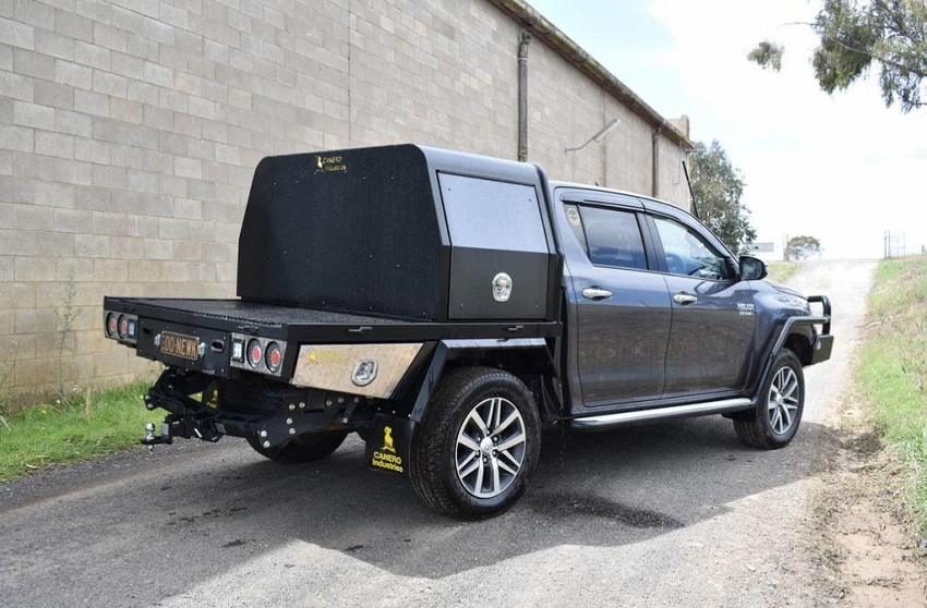 picture of a black mini canopy on a road beside a tall wall