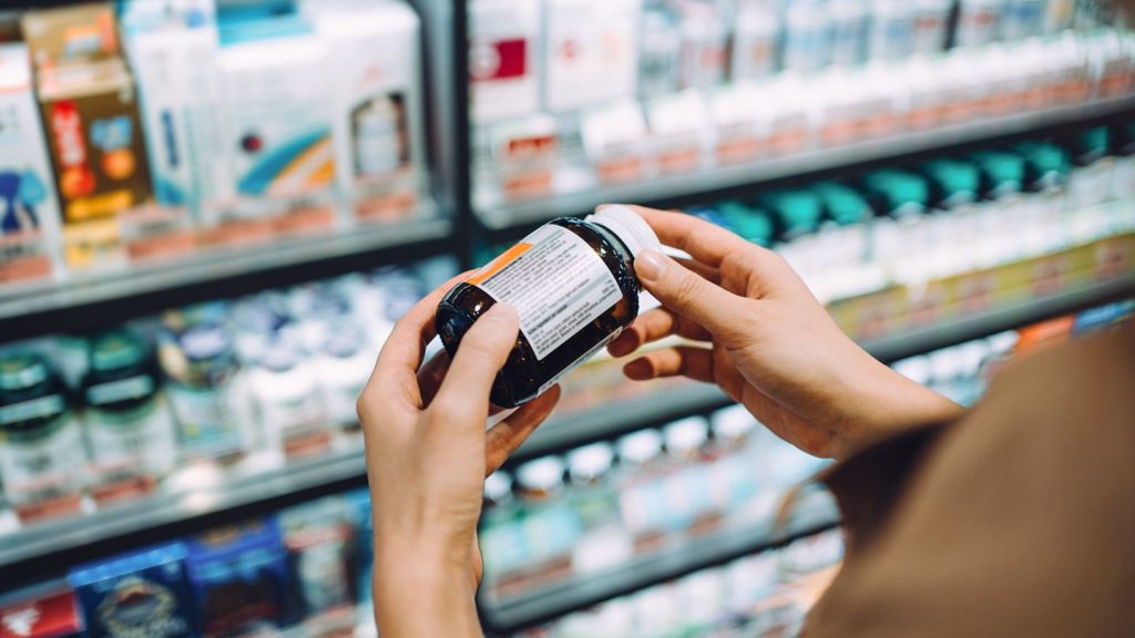 Woman holding in hand supplements