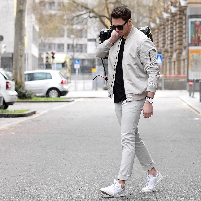 picture of a men walking the street wearing stylish outfit caring a bag