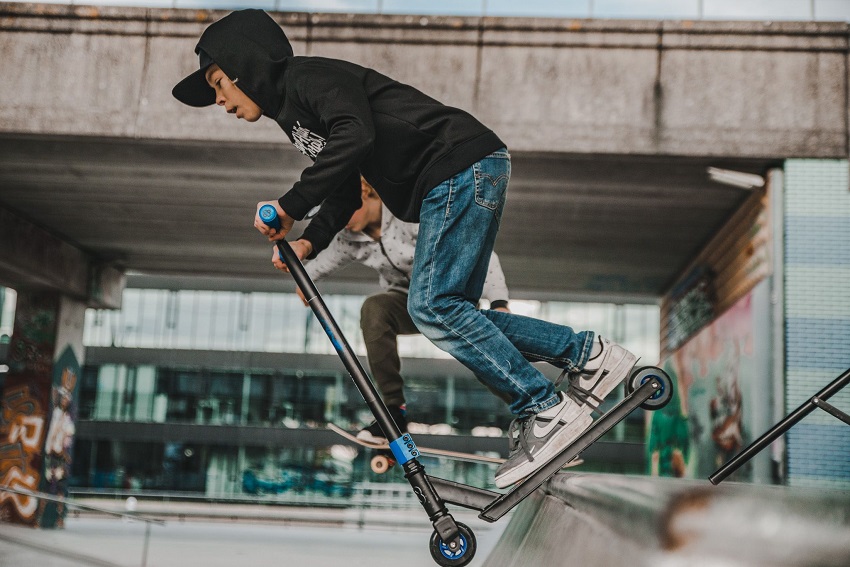 Kid riding a scooter in a skatepark