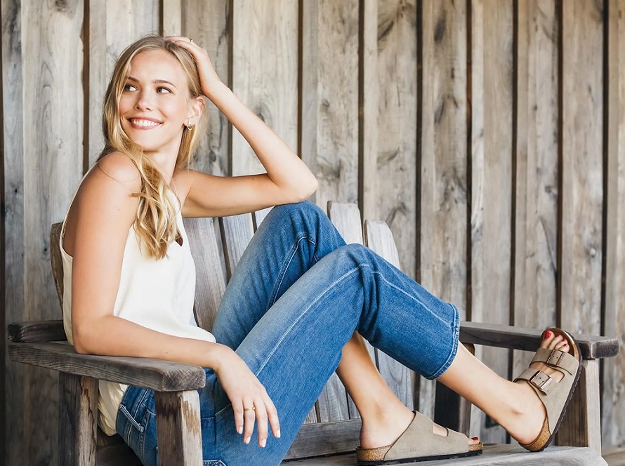 picture of a woman sittinh on a bench wearin casual outfit and brikenstock sandals