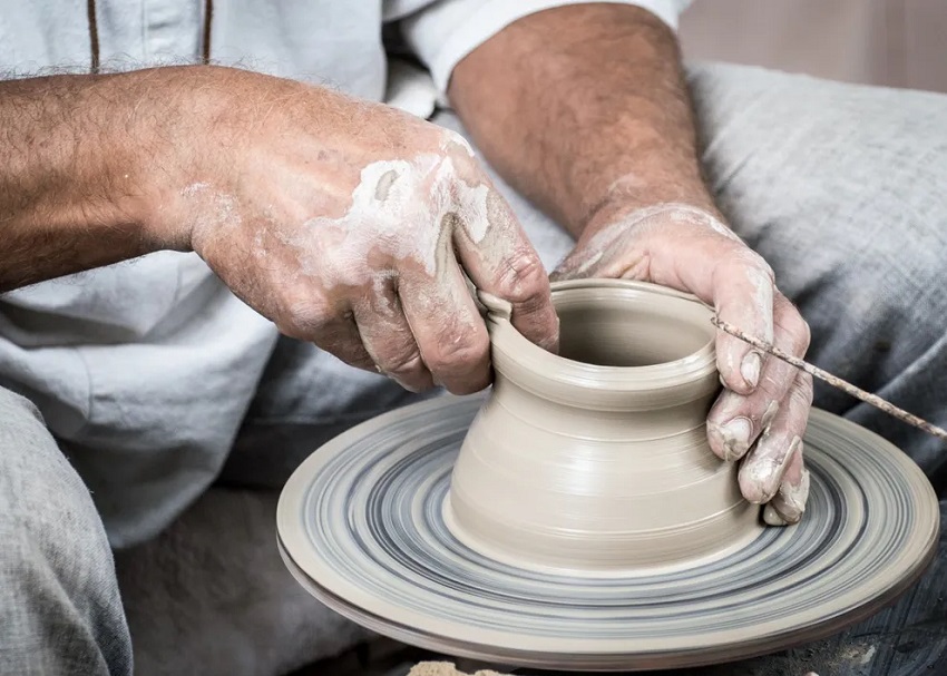 person making pottery on a wheel