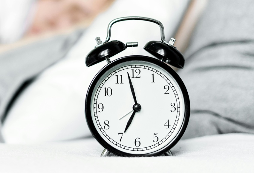 analogue alarm clock on the bed